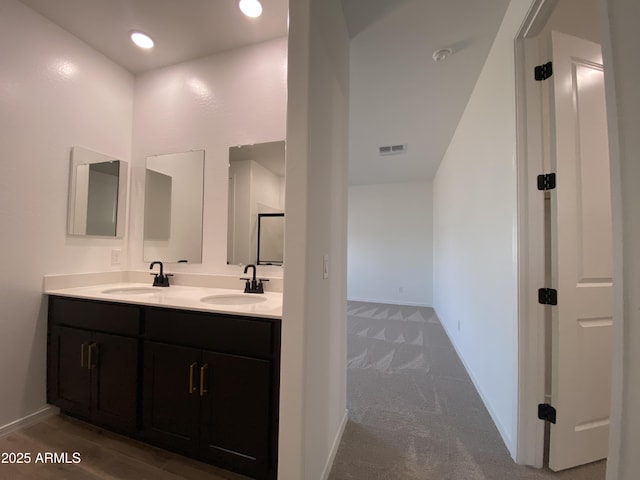 bathroom featuring visible vents, a sink, baseboards, and double vanity