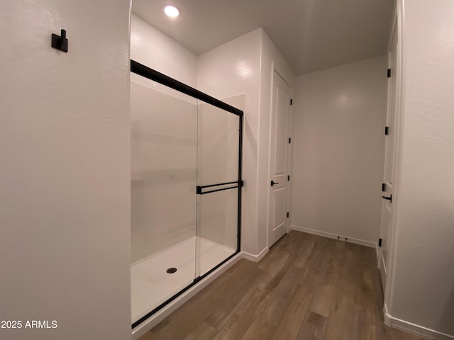 full bath with wood finished floors, a shower stall, and recessed lighting