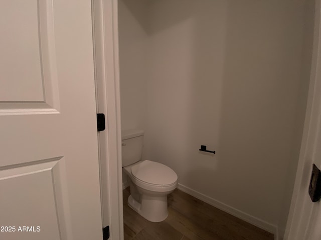 bathroom with wood finished floors, toilet, and baseboards