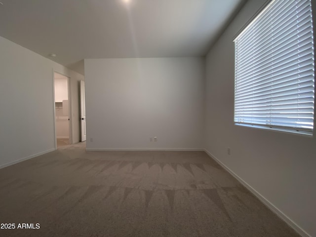 interior space with baseboards and light colored carpet