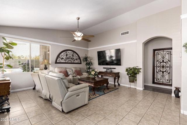 tiled living room with ceiling fan and lofted ceiling