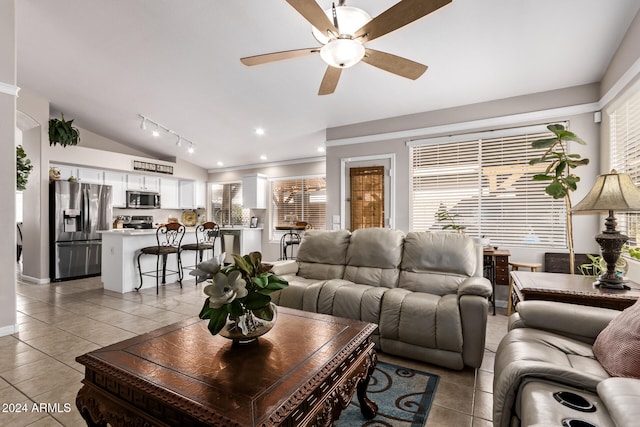 living room featuring ceiling fan, crown molding, light tile patterned floors, and lofted ceiling