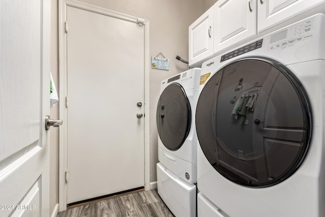 washroom with cabinets, hardwood / wood-style floors, and washer and clothes dryer