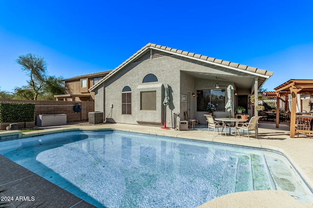 rear view of property featuring ceiling fan, cooling unit, a patio area, and a fenced in pool