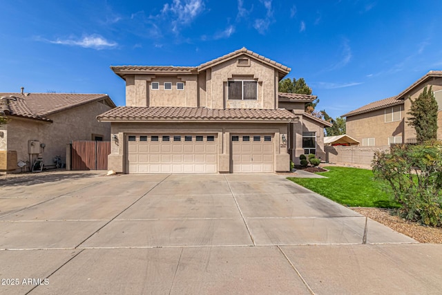 view of front of house with a tiled roof, fence, driveway, and stucco siding