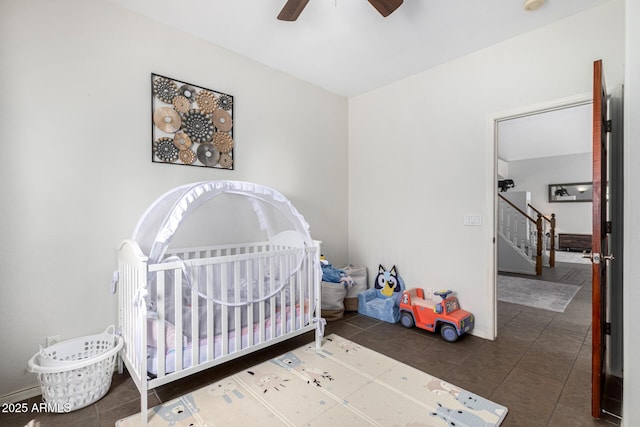 bedroom featuring tile patterned flooring, ceiling fan, and a crib