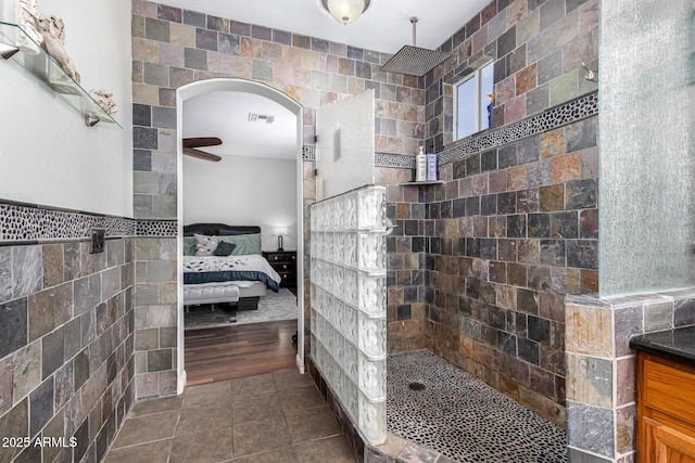 full bath featuring ensuite bath, visible vents, walk in shower, and tile walls