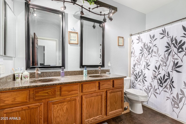 bathroom with double vanity, a sink, and toilet