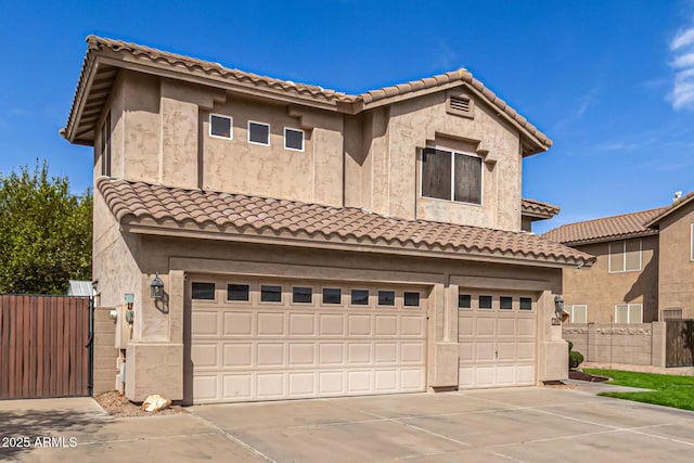 view of front of house featuring a garage, driveway, fence, and stucco siding