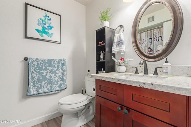 bathroom featuring vanity, wood-type flooring, and toilet