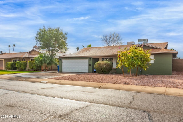 ranch-style house with a garage and central air condition unit