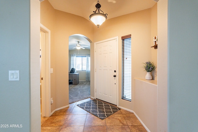 foyer entrance with tile patterned floors, ceiling fan, and lofted ceiling