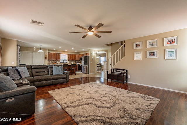 living room featuring ceiling fan and dark wood-type flooring