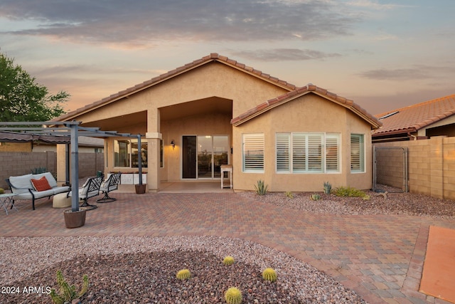 rear view of property featuring a fenced backyard, an outdoor living space, a pergola, and a patio area