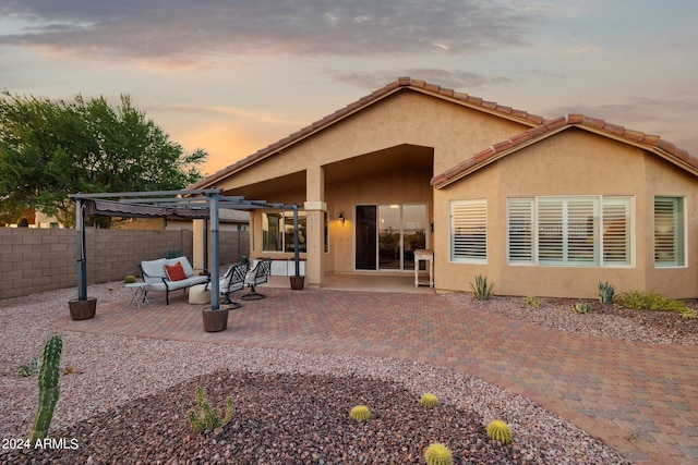 rear view of property with a pergola, stucco siding, a fenced backyard, a patio, and outdoor lounge area