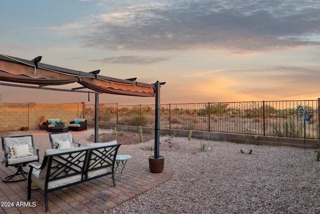 patio terrace at dusk featuring an outdoor hangout area and a fenced backyard