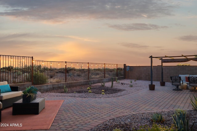 patio terrace at dusk featuring an outdoor hangout area and a fenced backyard