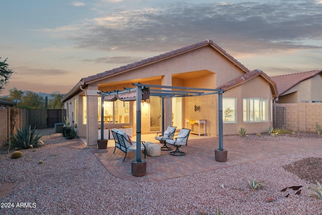 back of house at dusk with a patio area, a fenced backyard, stucco siding, and central air condition unit