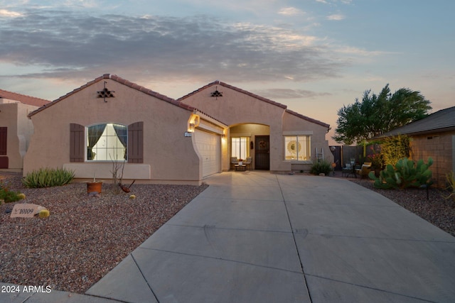 mediterranean / spanish-style house with concrete driveway, stucco siding, a garage, and a tiled roof