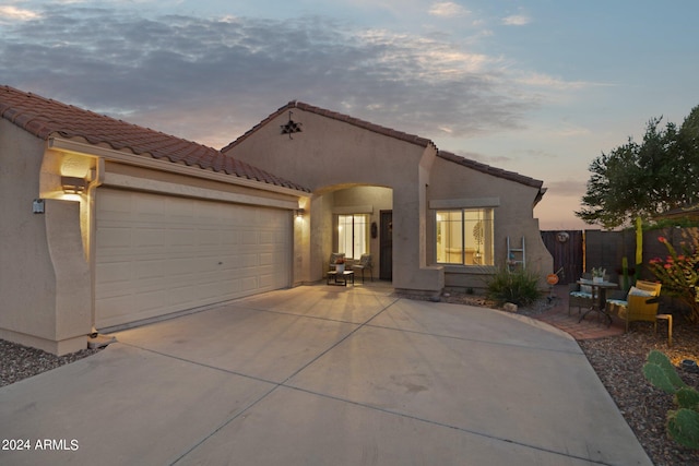 mediterranean / spanish-style house with concrete driveway, stucco siding, a garage, and a tiled roof