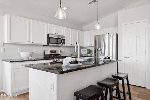 kitchen with stainless steel appliances, white cabinetry, hanging light fixtures, lofted ceiling, and a breakfast bar
