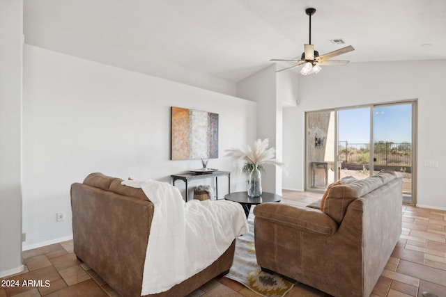 living area featuring ceiling fan, high vaulted ceiling, baseboards, and stone finish floors