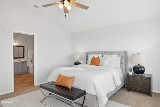 bedroom with light colored carpet, lofted ceiling, connected bathroom, baseboards, and a ceiling fan