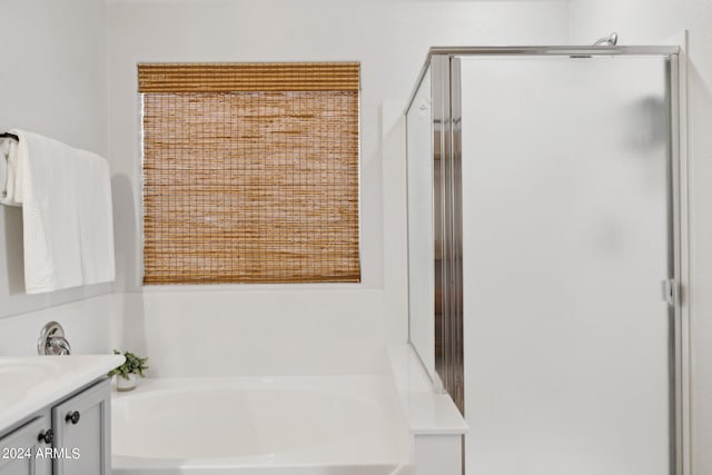 full bath featuring a shower stall, a garden tub, and vanity