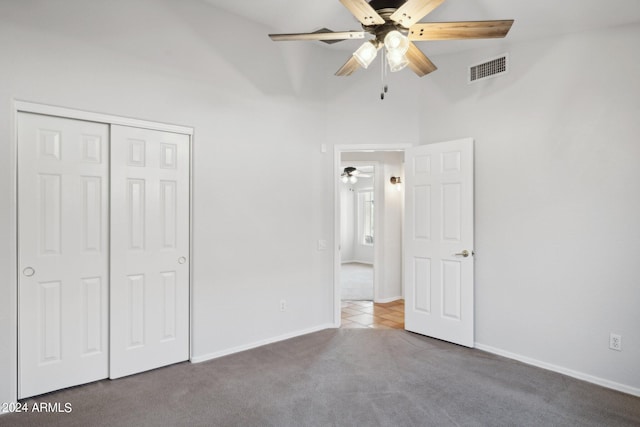 unfurnished bedroom featuring carpet flooring, a closet, baseboards, and ceiling fan