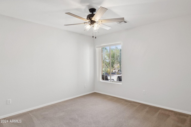carpeted empty room featuring ceiling fan and baseboards