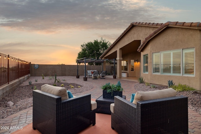 patio terrace at dusk featuring an outdoor hangout area and a fenced backyard