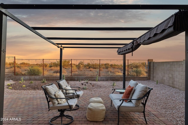patio terrace at dusk featuring a fenced backyard