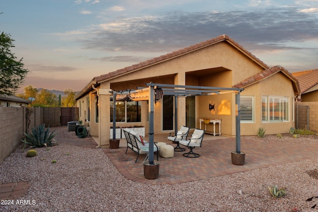 back of property with stucco siding, a fenced backyard, a patio area, and a pergola