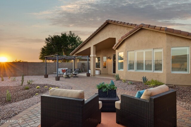 back of house with outdoor lounge area, a patio, a fenced backyard, a pergola, and stucco siding