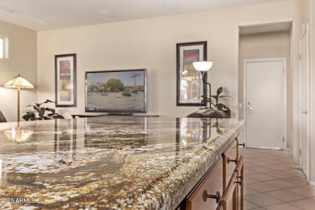 interior space with light tile patterned floors and stone countertops