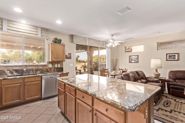 kitchen featuring sink, stainless steel dishwasher, a healthy amount of sunlight, and a kitchen island