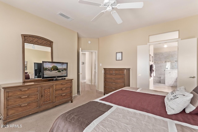 bedroom with ensuite bath, light colored carpet, and ceiling fan