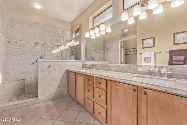 bathroom featuring vanity, a tile shower, and tile patterned floors