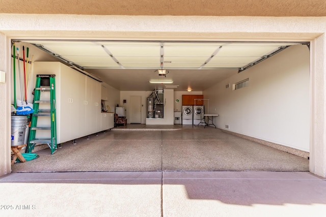 garage with a garage door opener, separate washer and dryer, and gas water heater