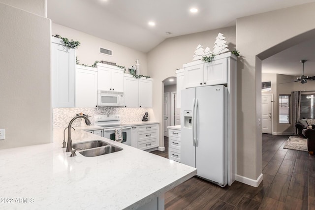 kitchen featuring white appliances, lofted ceiling, sink, and white cabinets