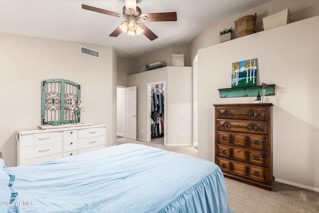 carpeted bedroom with a spacious closet, vaulted ceiling, a closet, and ceiling fan