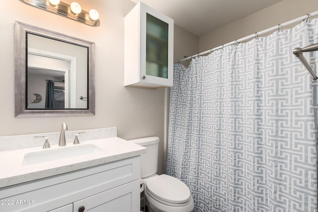 bathroom featuring vanity, toilet, and walk in shower