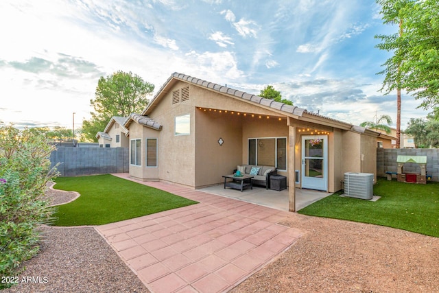 rear view of property with a yard, central air condition unit, and a patio area