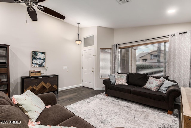 living room featuring dark hardwood / wood-style flooring, vaulted ceiling, and ceiling fan