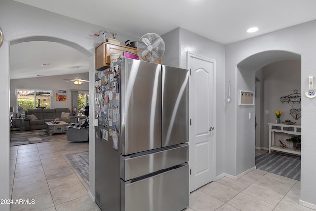 kitchen featuring light tile patterned floors, lofted ceiling, stainless steel refrigerator, and ceiling fan