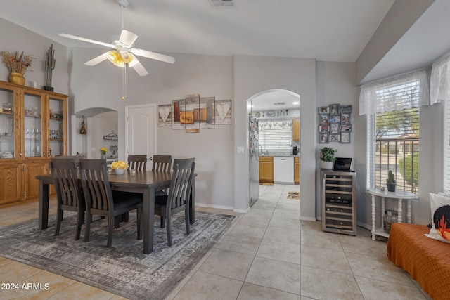 dining area featuring ceiling fan, beverage cooler, vaulted ceiling, and light tile patterned flooring