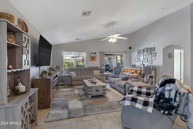 living room featuring ceiling fan, vaulted ceiling, and light tile patterned flooring