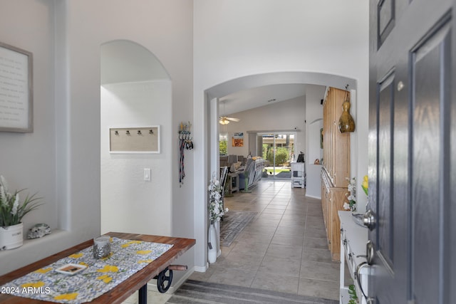 entryway with vaulted ceiling, light tile patterned floors, and ceiling fan