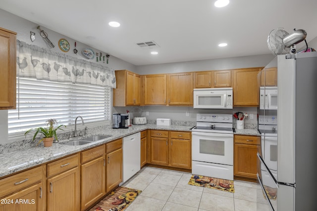 kitchen featuring white appliances, light stone countertops, light tile patterned flooring, and sink