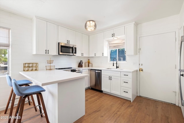 3737 E Turney Ave Unit 206, Phoenix, AZ 85018 - kitchen featuring stainless steel appliances, a sink, healthy amount of natural light, and a peninsula